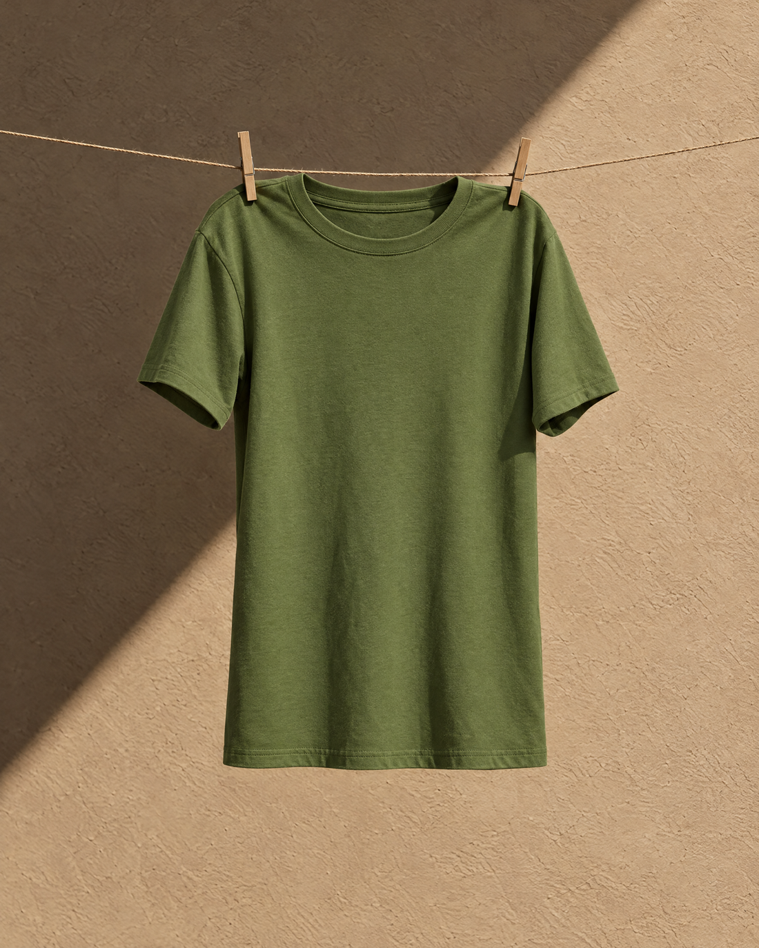Remera verde secándose a la sombra en una soga